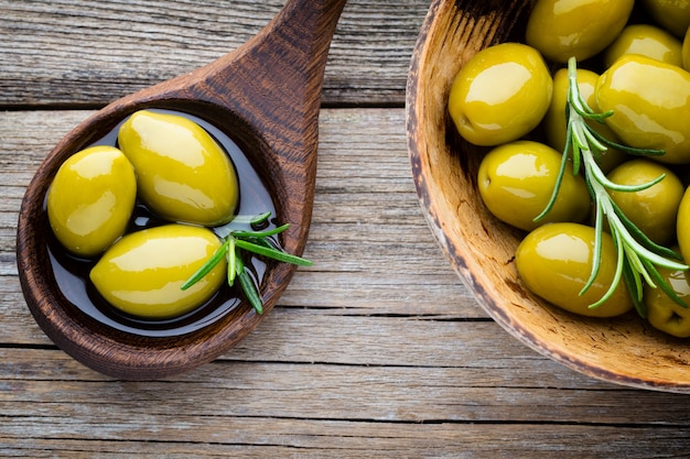 Aceitunas frescas y fondo gris. Aceitunas en bol y cuchara.