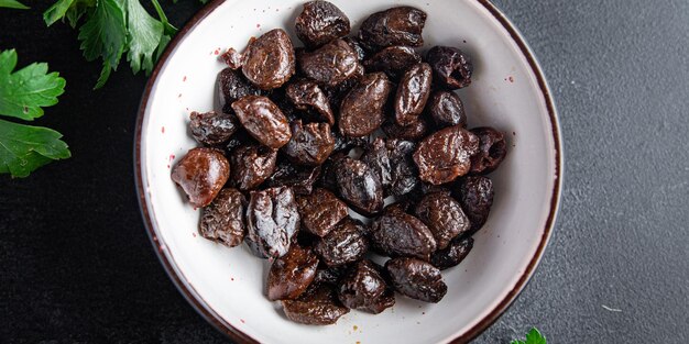 Aceitunas negras sin hueso frutos secos ahumados bocadillos en la mesa espacio de copia fondo de alimentos