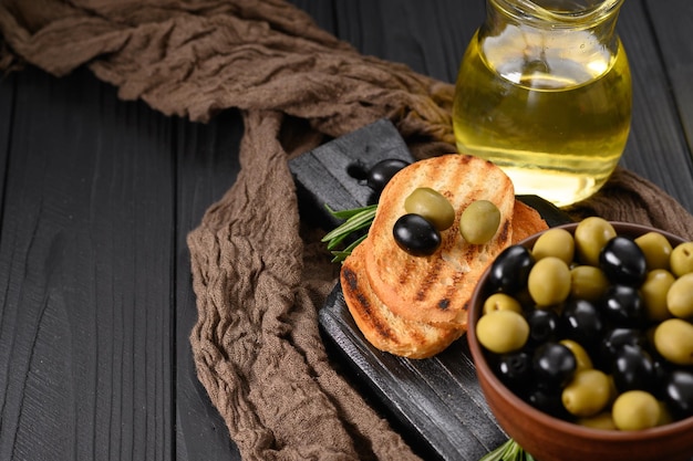 Aceitunas negras y verdes sobre un fondo negro de madera oscura