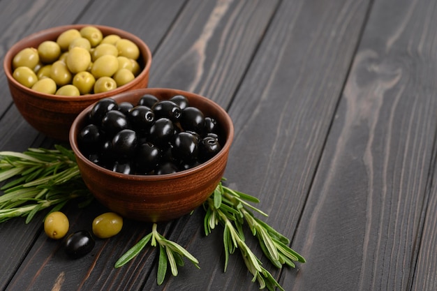 Aceitunas negras y verdes sobre un fondo rústico de madera oscura