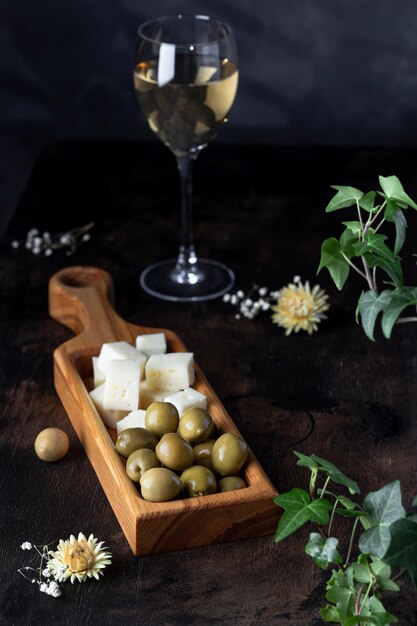 Aceitunas con queso casero sobre tabla de madera