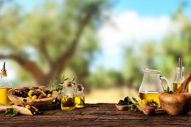 Aceitunas recién cosechadas en cuencos de madera y aceite prensado en botellas de vidrio