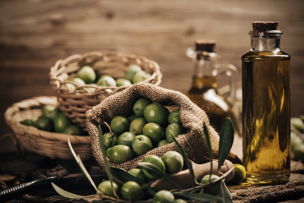 Aceitunas verdes y aceite de oliva en una botella de cerca