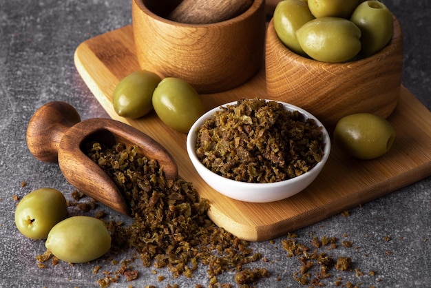 Aceitunas verdes secas en tazón de madera. Aceitunas en escabeche.