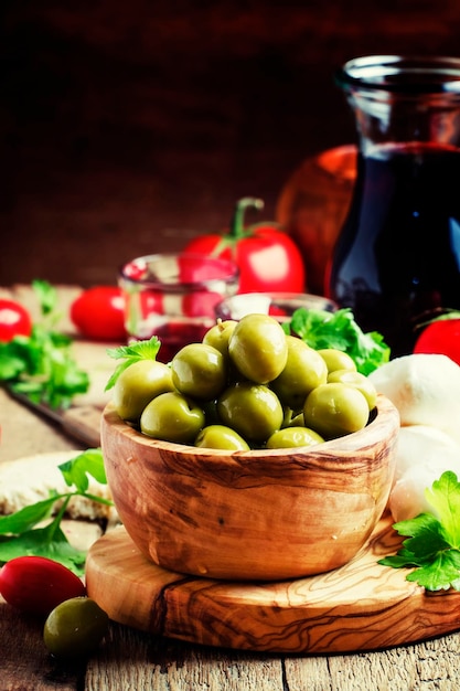 Aceitunas verdes en un tazón de madera enfoque selectivo