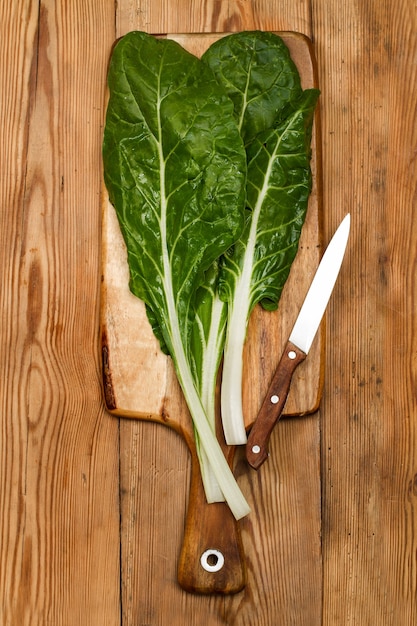 Acelgas sobre una tabla de cocina de madera en una vista superior