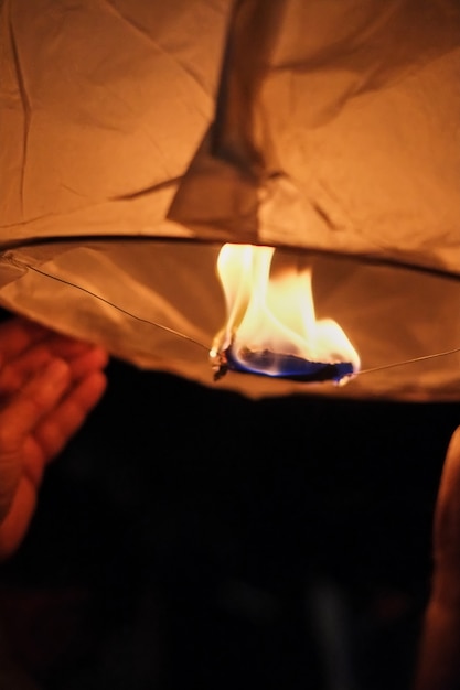 Acende uma lanterna de papel celestial antes de se lançar no céu escuro da noite