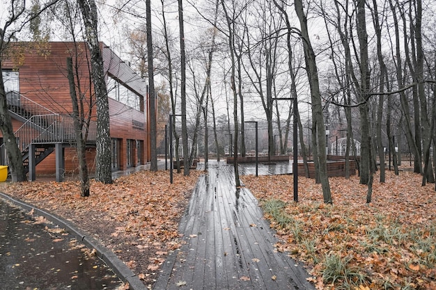 acera en un parque de otoño en la lluvia hecha de madera