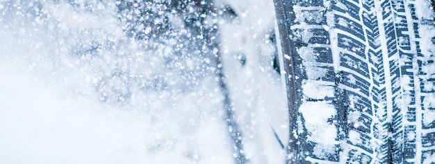Acercamiento de los neumáticos de invierno en una carretera cubierta de nieve en los fríos meses de invierno.