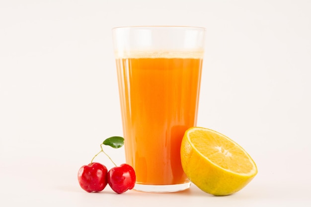 Acerola orgânica fresca e suco de laranja com acerola fatiada e fruta laranja em um copo de vidro em fundo branco em vista superior