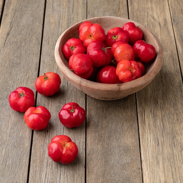 Acerolas o cerezas de Barbados en un recipiente sobre una mesa de madera