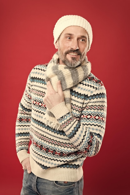 Acessórios de malha estilo de inverno conceito de moda masculina coleção de moda roupas de moda condições frias de inverno homem barbudo bonito usando chapéu e cachecol fundo vermelho moda de inverno