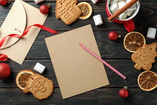 Acessórios de Natal e lista de desejos em branco na mesa de madeira, vista superior