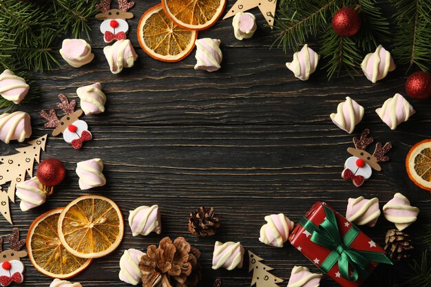 Acessórios de natal e marshmallow em fundo de madeira