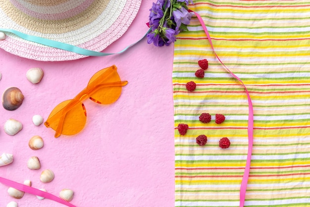 Foto acessórios de verão. chapéu de palha feminino com um cobertor em que são framboesas.