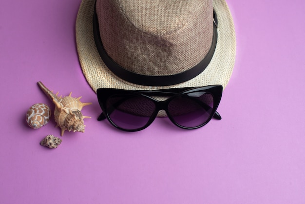 Acessórios de verão, conchas, chapéu e óculos de sol. férias de verão e conceito de mar.