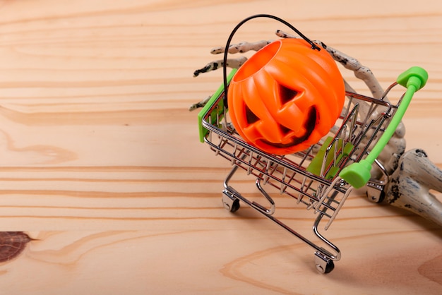 Acessórios e fantasia de Halloween em compras, carrinho de compras sobre madeira