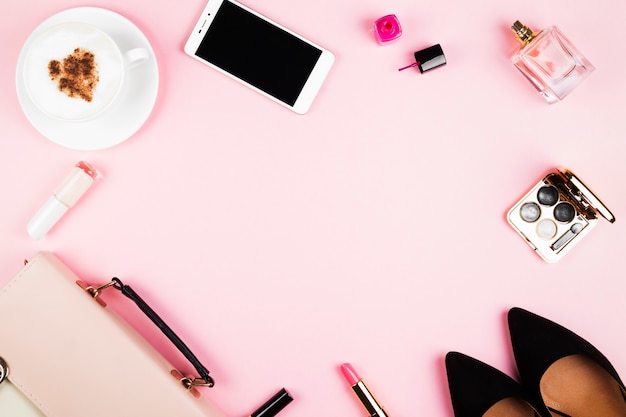Acessórios femininos - sapatos, bolsa, cosméticos, perfume, telefone, cappuccino no espaço rosa. espaço feminino e moda. vista superior, espaço de cópia