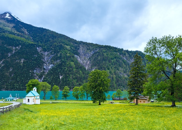 Achensee (lago Achen) paisaje de verano e iglesia en una pradera floreciente (Austria).