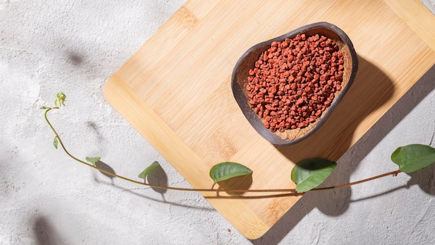 Achiote-Körner in Holzschale auf weißem Hintergrund Bixa orellana