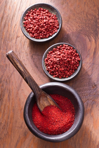 Achiote en un tazón sobre fondo de madera pasta de achiote