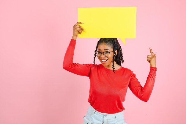 Acho que uma mulher afro pensativa olhando para uma bolha de fala em branco tocando seu queixo copyspace parede rosa do estúdio