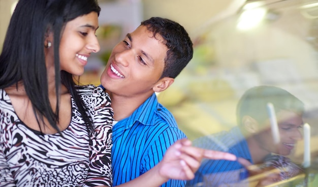 Acho que vou ter esse sabor Foto de um jovem casal afetuoso olhando sorvete pela vitrine de uma loja