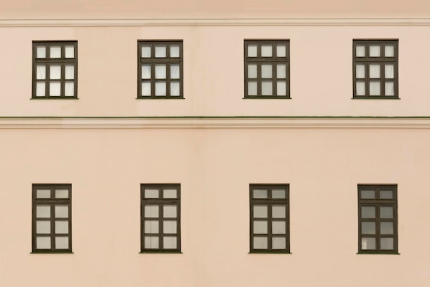 Acht Fenster mit braunem Rahmen auf der beige getönten Wand