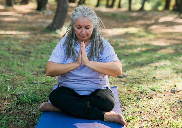 Achtsames Seniorenporträt mit Dreadlocks, die über die Natur meditieren, Nahaufnahme, Kopienraum, Wellness- und Yoga-Praxis