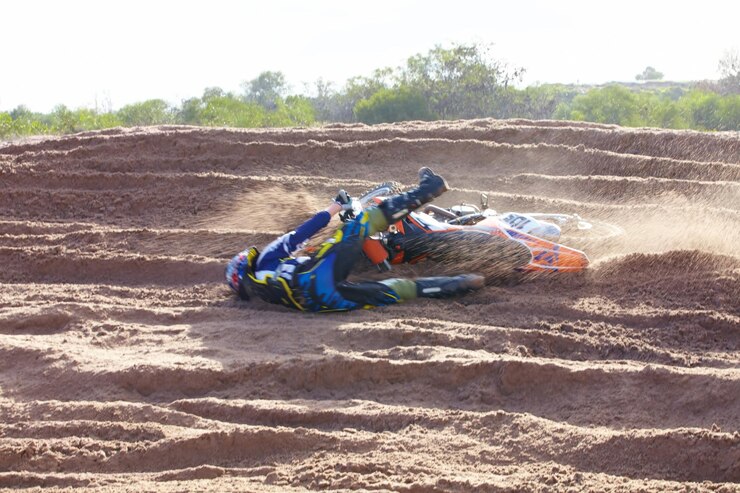 Foto acidente de areia e motocicleta para esportes com ação para desafio ou competição com potência velocidade erro e deserto com bicicleta para corrida ou aventura ao ar livre com liberdade ou condução destemida