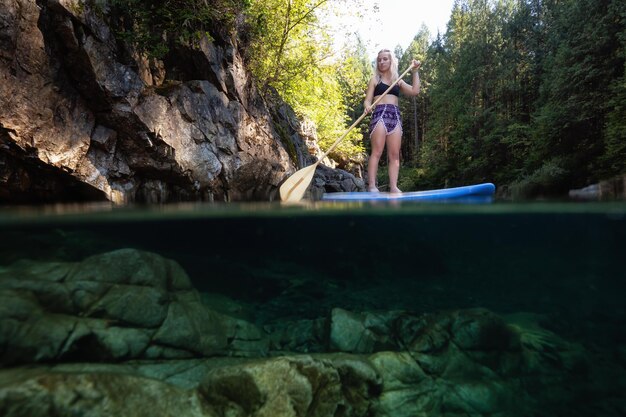 Acima e abaixo da foto de uma jovem caucasiana embarcando em um rio