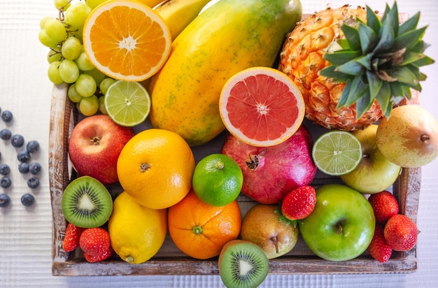 Acima, vista de uma cesta de madeira cheia de frutas frescas e cores. Estilo de vida e alimentação saudáveis