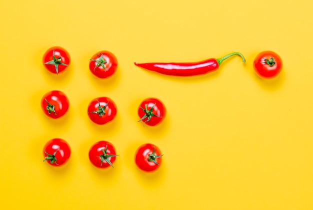 Acima vista em pimenta e tomate em fundo amarelo