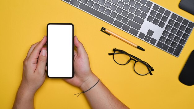 Acima vista homem usando telefone inteligente no espaço de trabalho criativo.