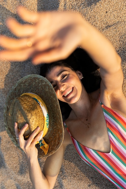 Foto acima vista sorridente mulher deitada na praia