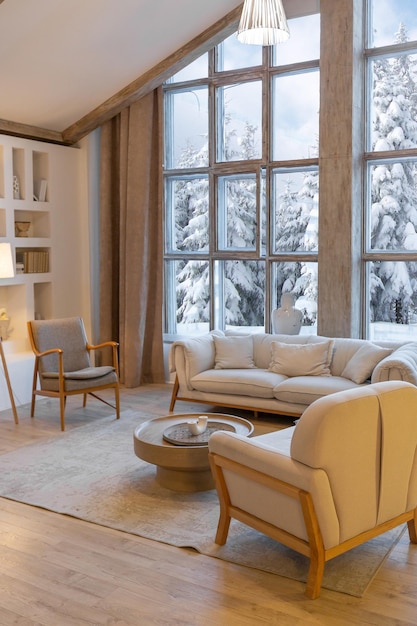 Acogedor y cálido interior de un elegante chalet de campo con una enorme ventana panorámica con vistas al bosque de invierno, decoración de madera de planta abierta, colores cálidos y un hogar familiar