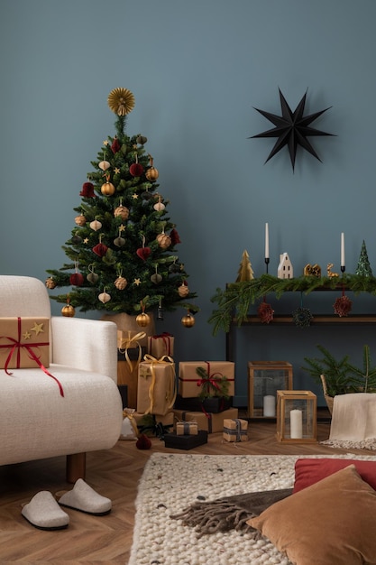 Acogedor y elegante interior de la sala de estar de Navidad con sillón de diseño regalos de árbol de Navidad linternas de madera pared azul almohada roja decoración de bolas de Navidad Santa Claus está llegando plantilla.