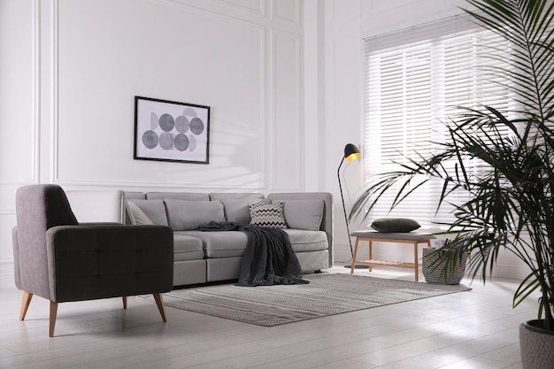 Acogedor salón interior con cómodo sofá gris y sillón