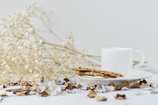 Acogedora casa con una taza de café y una rama de flores