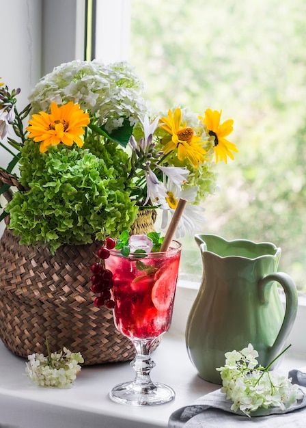 Acogedora casa de verano naturaleza muerta ramo de flores vaso de jarra de limonada en la ventana