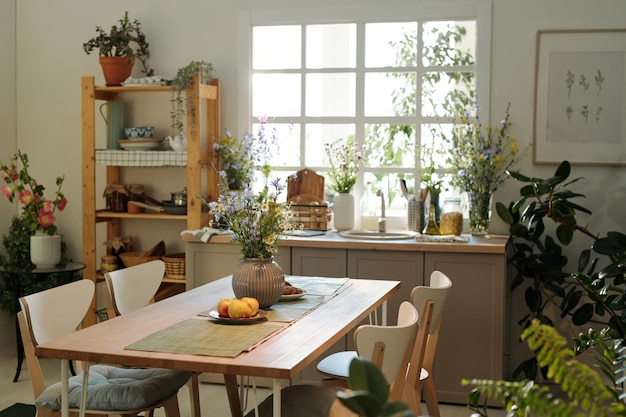 Acogedora cocina con mesa de madera en el centro rodeada de fregadero con menaje