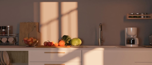 Acogedora cocina moderna con mostrador blanco, cafetera, utensilios de cocina y frutas.