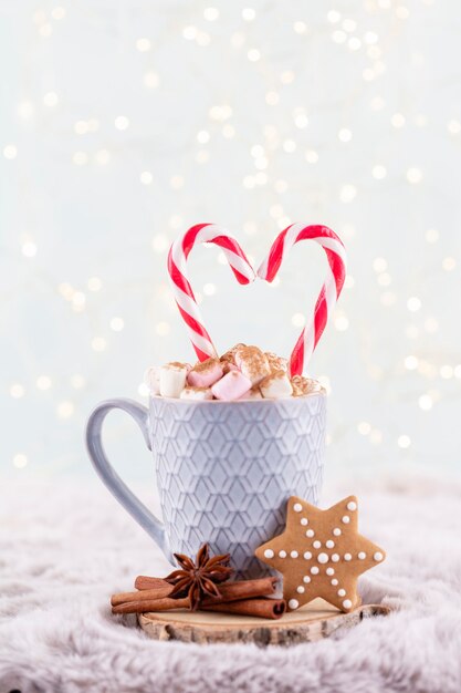 Acogedora composición navideña con una taza y galletas. Chocolate caliente con malvavisco.