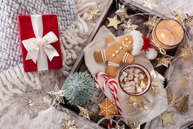 Acogedora composición navideña con una taza y galletas. Chocolate caliente con malvavisco.