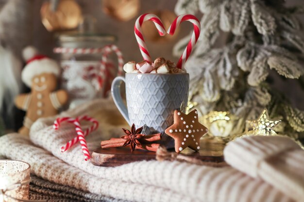 Acogedora composición navideña con una taza y galletas. Chocolate caliente con malvavisco.