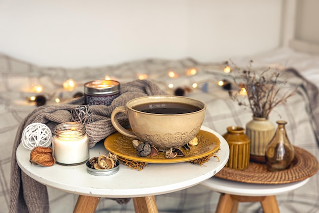 Acogedora composición otoñal con una taza de té y detalles decorativos