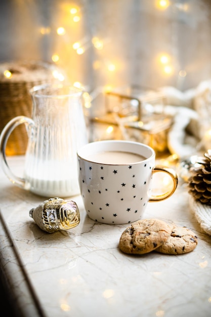 Acogedora decoración de vacaciones de invierno Luces navideñas y taza de café con detalles de decoración hogar real