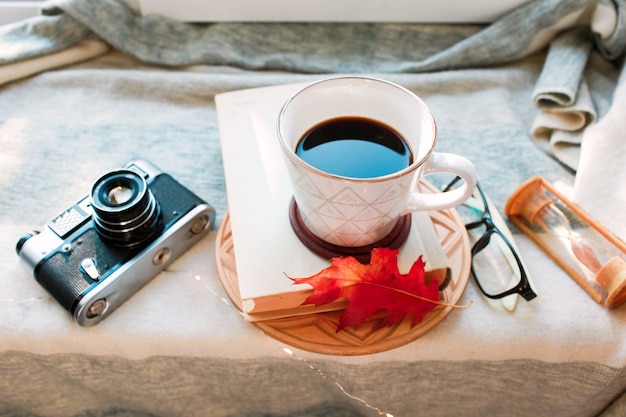 Acogedora mañana de otoño con una taza de café con crema y hojas de otoño