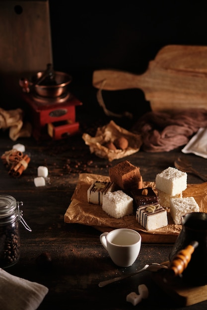 Una acogedora mesa de café en la cocina. Dulces, café, canela. Dulces y atributos para hacer café. La gente va a tomar café y comer postre.