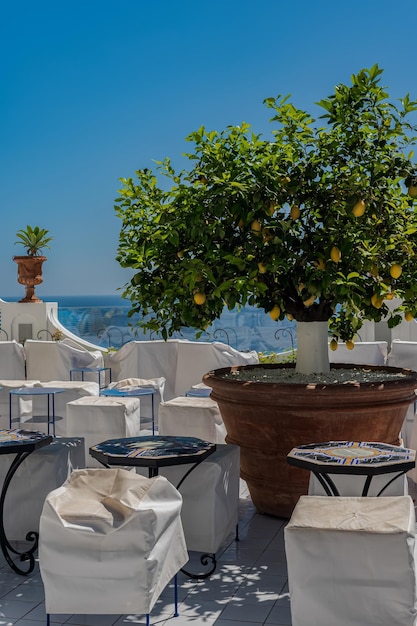 Acogedora mesa en un café con un mantel blanco con una hermosa vista de la ciudad de Positano en Italia